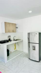 a white kitchen with a refrigerator and a sink at Apartamento Marbar 1 in Cartagena de Indias