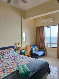 a bedroom with a bed and a view of the ocean at Seafront Corus Resort Port Dickson in Port Dickson