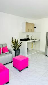 a living room with pink stools and a kitchen at Apartamento Marbar 1 in Cartagena de Indias