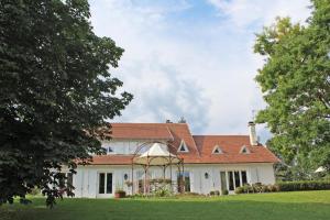 una gran casa blanca con techo rojo en La musardiere de louisiane en Saint-Brice-sur-Vienne