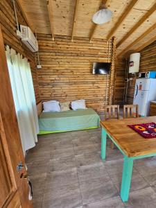 a room with a bed and a table in it at Campo Cuyen, Cabañas in Lobos