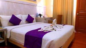 Postel nebo postele na pokoji v ubytování Puri Saron Denpasar Hotel