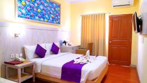 Postel nebo postele na pokoji v ubytování Puri Saron Denpasar Hotel