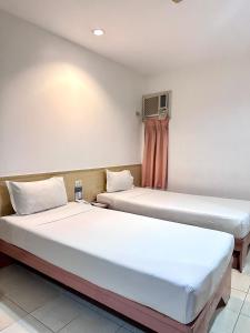 2 Betten nebeneinander in einem Zimmer in der Unterkunft Hotel Pier Cuatro in Cebu City