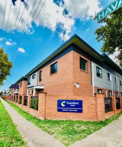 un edificio de ladrillo rojo con un cartel. en Comfort Inn Serenity Bathurst, en Bathurst