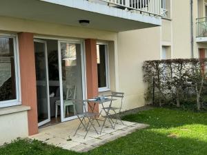 een patio met 2 stoelen en een tafel voor een gebouw bij Appartement Cabourg, 2 pièces, 4 personnes - FR-1-487-266 in Cabourg