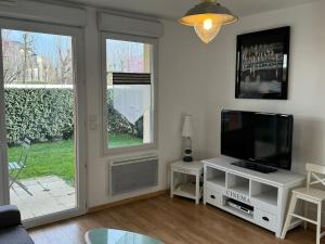 een woonkamer met een tv en een raam bij Appartement Cabourg, 2 pièces, 4 personnes - FR-1-487-266 in Cabourg