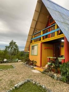 a red and yellow house with a blue roof at Villa Alpina in San Felipe de Puerto Plata