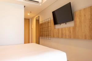 Schlafzimmer mit einem Bett und einem Flachbild-TV in der Unterkunft Anagata Tanjung Benoa Bali in Nusa Dua