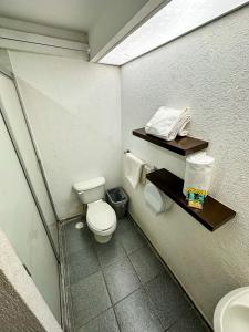 a small bathroom with a toilet and a sink at Hotel Montreal in León