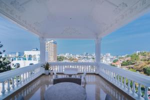 a balcony with a white railing and a table and chairs at The View Hotel in Vung Tau