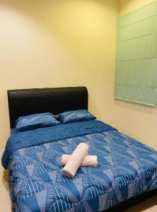 a bed with two towels on top of it at 139 Homestay 13 Mins From kuching Airport Baby Friendly Spacious Home in Kota Samarahan