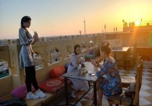 un gruppo di ragazze sedute a un tavolo su un balcone di Hotel Royal Lakhina Jaisalmer a Jaisalmer