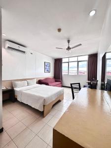 um quarto de hotel com uma cama e uma sala de estar em Hotel Pier Cuatro em Cebu