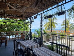 a patio with tables and chairs and the ocean at West Life Bungalow Phu Quoc in Phu Quoc