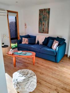 een woonkamer met een blauwe bank en een tafel bij Beautiful 1 bedroom cottage on 1 acre in Sandford