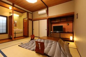 a room with a bed and a television in it at Echigoya Ryokan in Ogano