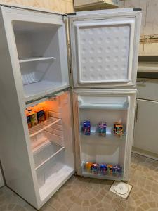 einen offenen Kühlschrank mit Speisen und Getränken in der Unterkunft العلم نور2 in Sīdī Ḩamzah