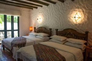 een slaapkamer met 2 bedden en 2 verlichting aan de muur bij Casa San Nicolas in Villa de Leyva