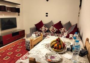 een woonkamer met een tafel en een bank bij Nile House in Abu Simbel
