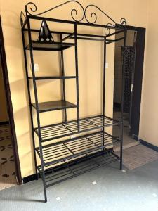 a metal shelf in a room next to a wall at Independent room on Island in colonial house with private entrance in Saint-Louis