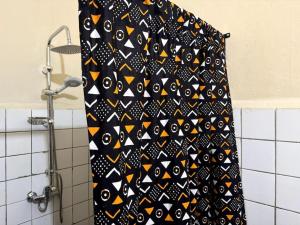 a black and yellow shower curtain in a bathroom at Independent room on Island in colonial house with private entrance in Saint-Louis