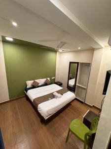 a bedroom with a large bed with a green wall at David Residency in Madurai