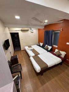 a large bedroom with two beds and a television at David Residency in Madurai