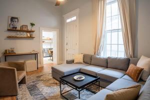 a living room with a couch and a table at Remodeled Modern Home - private backyard & games! in Louisville +43 photos