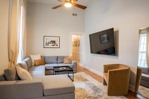 a living room with a couch and a tv at Remodeled Modern Home - private backyard & games! in Louisville