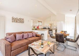 a living room with a couch and a table at Wareham Forest Lodge Retreat in Lytchett Minster