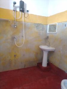 ein Bad mit einem Waschbecken und einer Dusche in der Unterkunft Our Little Secret in Kalutara