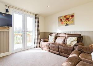 a living room with a couch and a television at Pickering Lodges in Pickering