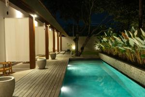uma piscina no meio de um pátio à noite em Rarama Living Studio em Kerobokan