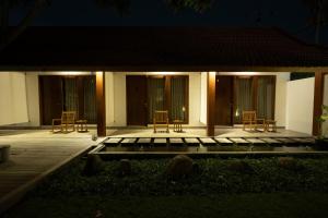 uma casa com cadeiras e um alpendre à noite em Rarama Living Studio em Kerobokan