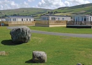 a large rock sitting on the grass in a field at Sunbeach Holiday Park in Llwyngwril