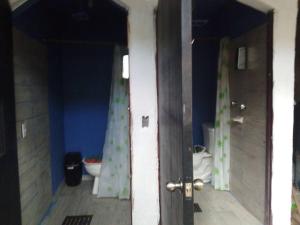 um corredor com uma casa de banho com WC e uma porta em Casa completa familiar, dos cuartos. em San Agustin de las Juntas