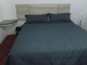 uma cama com um edredão azul e almofadas azuis em Casa completa familiar, dos cuartos. em San Agustin de las Juntas