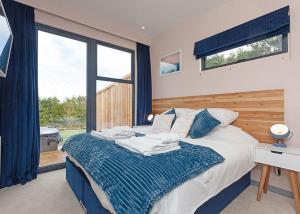 a bedroom with a bed with a desk and a window at Swanborough Lakes in Lewes