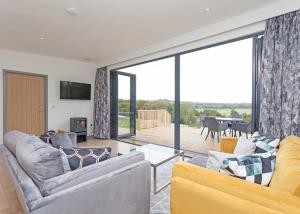 una sala de estar con 2 sofás y una puerta corredera de cristal en Swanborough Lakes en Lewes