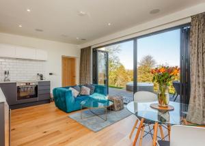 sala de estar con sofá azul y mesa de cristal en Swanborough Lakes en Lewes