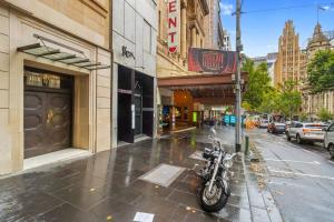 una motocicleta estacionada en una acera frente a un edificio en Regent Residence on Collins with Free WiFi en Melbourne