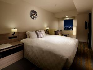 um quarto de hotel com uma cama grande e uma secretária em Sunshine City Prince Hotel Ikebukuro em Tóquio