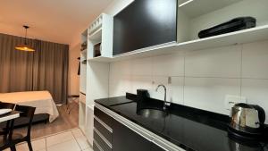 a kitchen with a sink and a room with a bed at Apto em São Paulo - Expo Center, Tietê, Anhembi in Sao Paulo