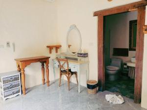 a bathroom with a vanity with a mirror and a toilet at Swiss Hotel Pattaya in Sattahip +32 photos