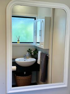 La salle de bains est pourvue d'un lavabo et d'une fenêtre. dans l'établissement Sea View Apartment, à Whangaparaoa