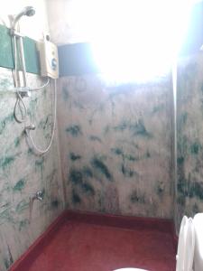 uma casa de banho com um chuveiro e um WC. em Our Little Secret em Kalutara