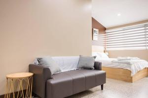 een slaapkamer met een bed en een bank en een bed bij NEW! Ideal 1BR Unit in the Hot Spot of Surry Hills in Sydney