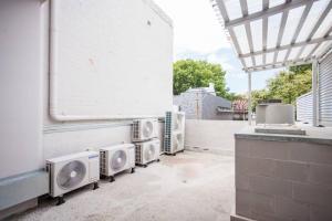 een patio met vier airconditioners op een gebouw bij NEW! Ideal 1BR Unit in the Hot Spot of Surry Hills in Sydney