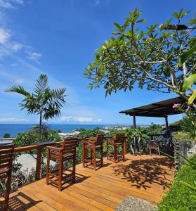 eine Terrasse mit Stühlen und Meerblick in der Unterkunft Sanalae Apartments in Honiara